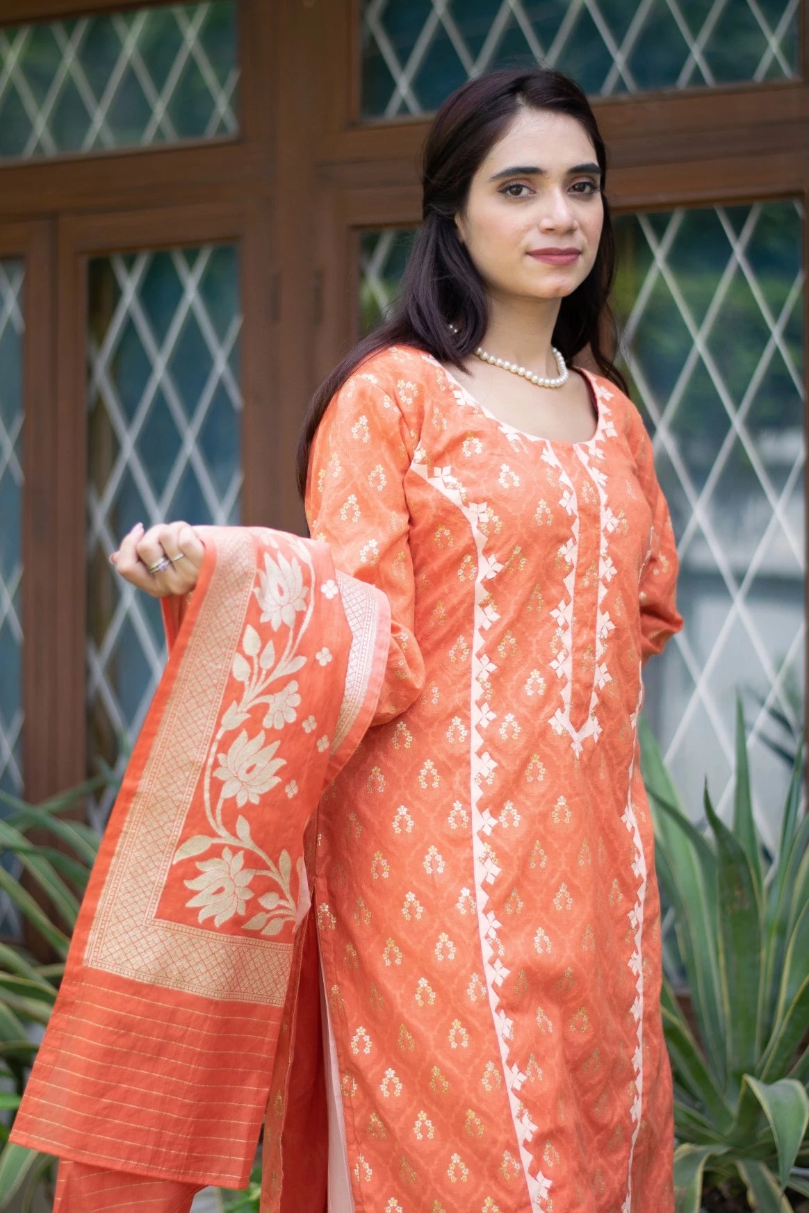 An ethnic outfit consisting of an orange silk kurta and pants