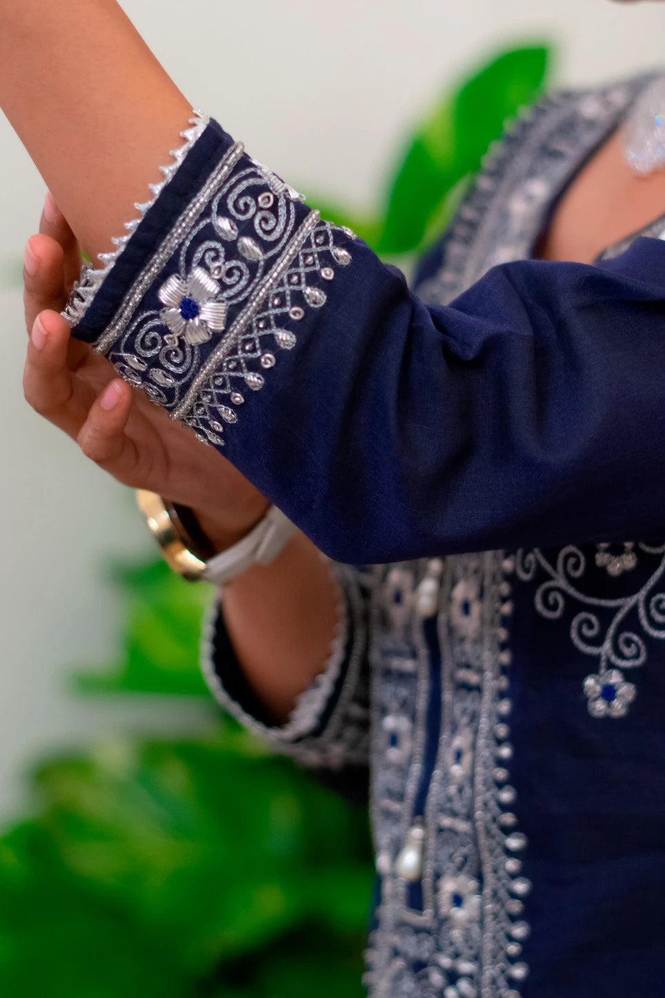 An Indian bride adorned in a heavily embroidered blue kurta and dupatta, looking stunning and regal on her wedding day.