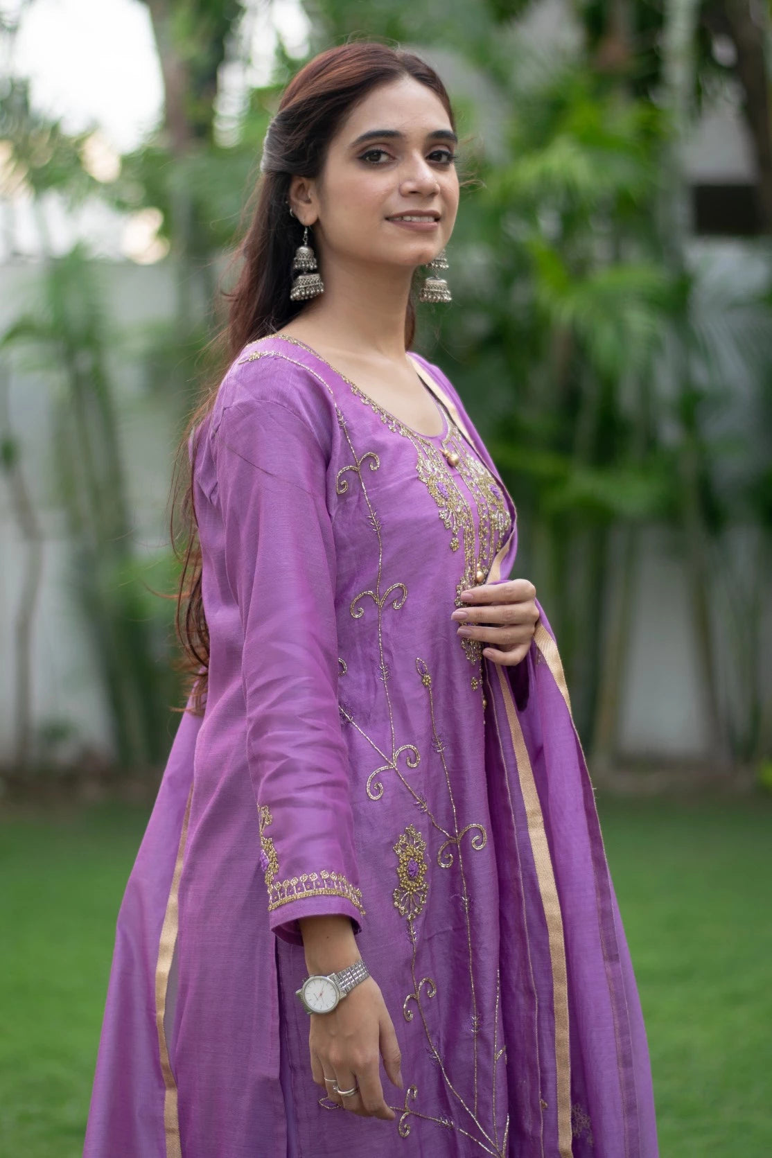 A woman's outfit is on display, featuring a bold purple lilac kurta with matching trousers, perfect for any occasion.