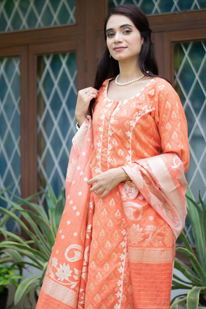 A female model wearing an orange silk kurta and matching trousers