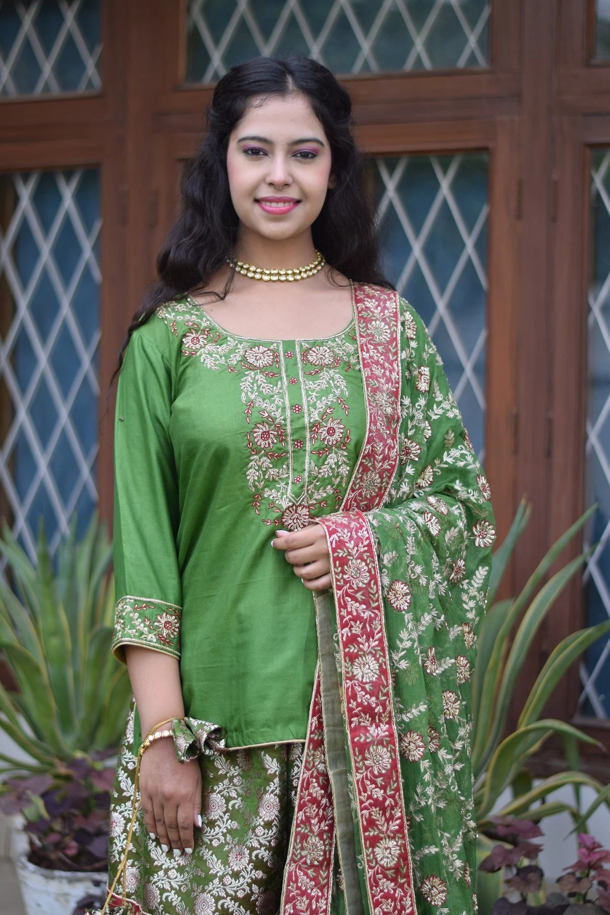 A striking green silk and kamkhab zardozi embroidered gharara suit worn for an Indian wedding.